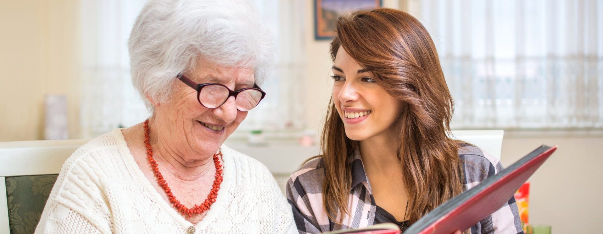 Senior showing granddaughter photobook to preserve her legacy