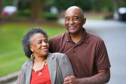 older couple hugging and smiling in park